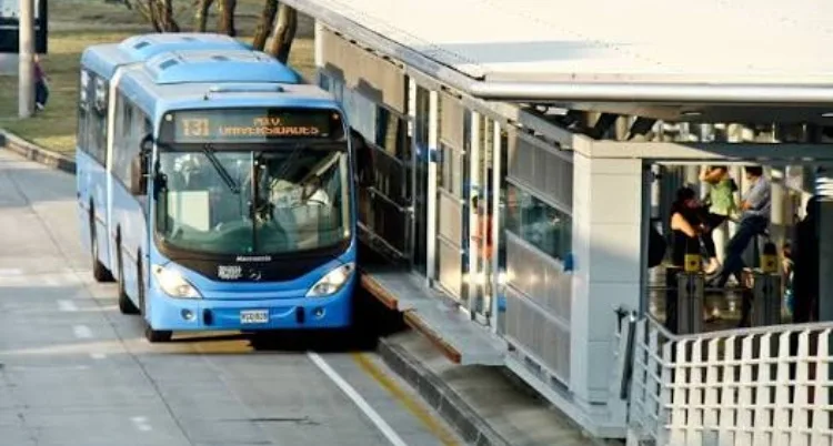 Un habitante de calle viaja dormido debajo del motor de un bus de transporte masivo